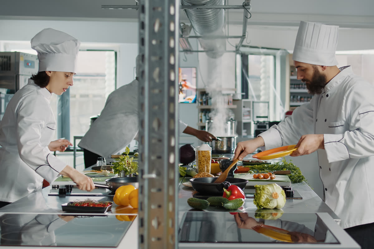 Profesyonel restoran mutfağında hijyen standartlarına uygun gıda hazırlığı — temiz tezgahlar, düzenli çalışma alanı